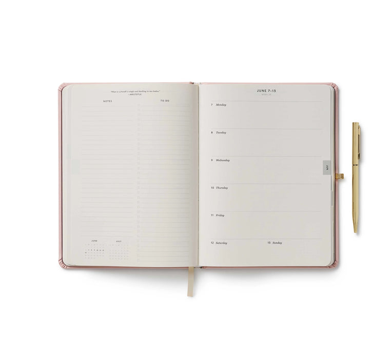 Open planner with a pen on a white background