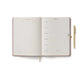 Open planner with a pen on a white background