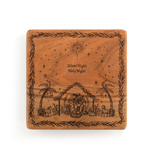 A square wooden plaque featuring an engraved Holy Night nativity scene with palm trees, animals, stars, and the text 'Silent Night Holy Night' in the center, shown on a plain white background.