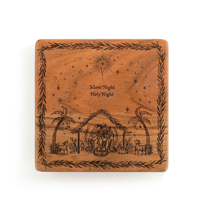 A square wooden plaque featuring an engraved Holy Night nativity scene with palm trees, animals, stars, and the text 'Silent Night Holy Night' in the center, shown on a plain white background.
