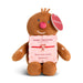 A brown plush gingerbread person toy holding a pink Christmas gift box with a red candy cane bow. The toy has a round pink nose, embroidered white details on its arms, and a red hanging tag that reads DEMDACO.