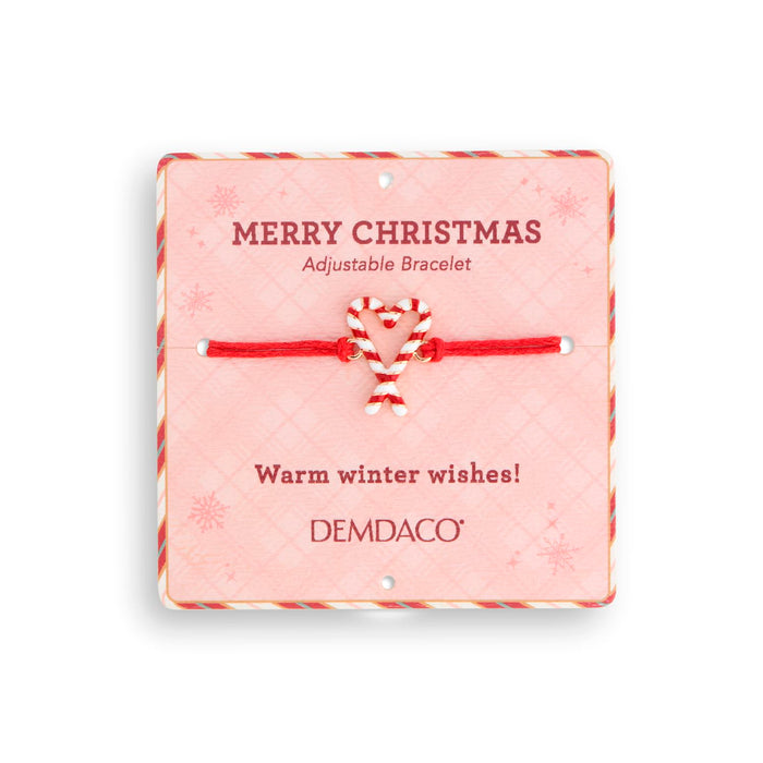 A red and white candy cane adjustable bracelet on a pink holiday-themed presentation card with 'DEMDACO' branding, set against a plain white background.