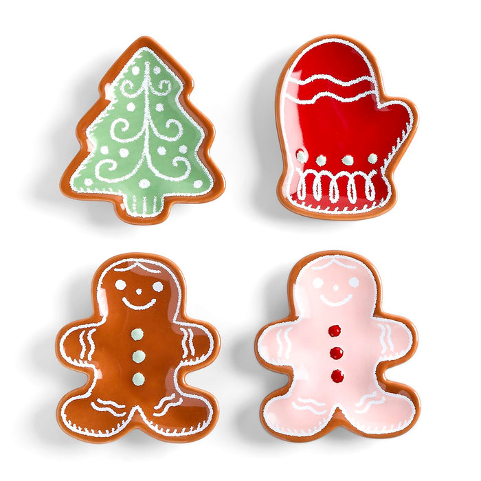 Four Christmas-themed cookies shaped like a tree, mitten, gingerbread man, and snowman on a white background.