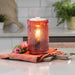 Pink textured wax warmer on a kitchen counter with flowers and a cutting board.