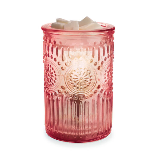 Pink textured candle holder with a lit candle inside on a white background