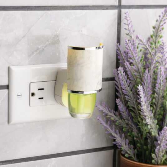 Wall-mounted night light with a plant on a tiled wall background