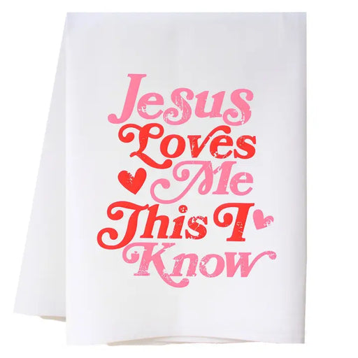 White towel with pink and red text 'Jesus Loves Me This I Know' on a white background