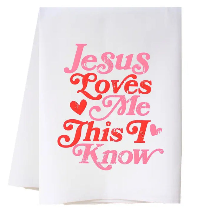 White towel with pink and red text 'Jesus Loves Me This I Know' on a white background
