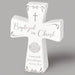 Decorative cross with engraved text on a gray background