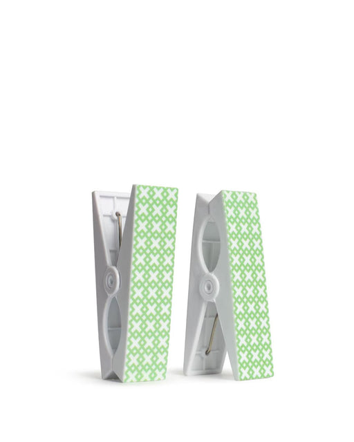 Two clothespins with green patterned straps on a white background