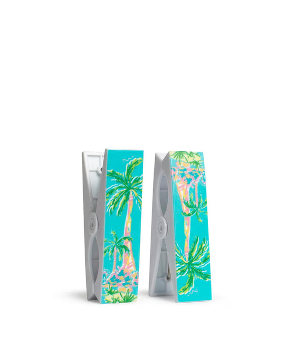 Two clothespins with tropical palm tree design on a white background