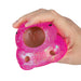 Pink glittery stress ball with brown buttons held in a hand on a white background