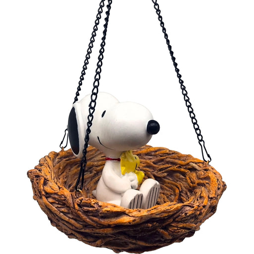 Snoopy figurine in a nest with a swing on a white background