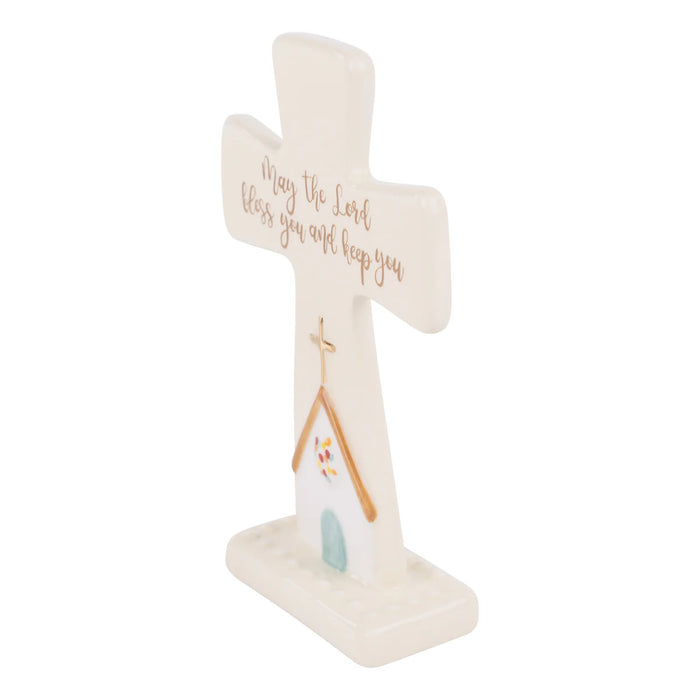 Decorative cross with a house illustration and text on a white background