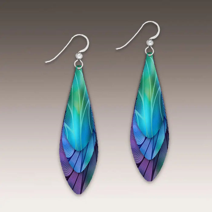 Pair of colorful feather-shaped earrings on a neutral background