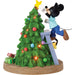 Mickey Mouse decorating a Christmas tree with lights and ornaments on a white background