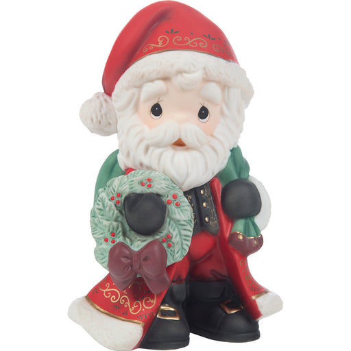 Decorative figurine of a Santa Claus holding a wreath on a white background