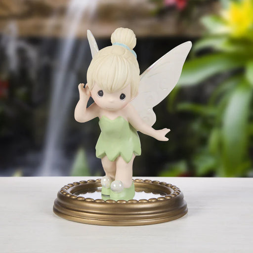 Fairy figurine on a decorative stand with a blurred natural background