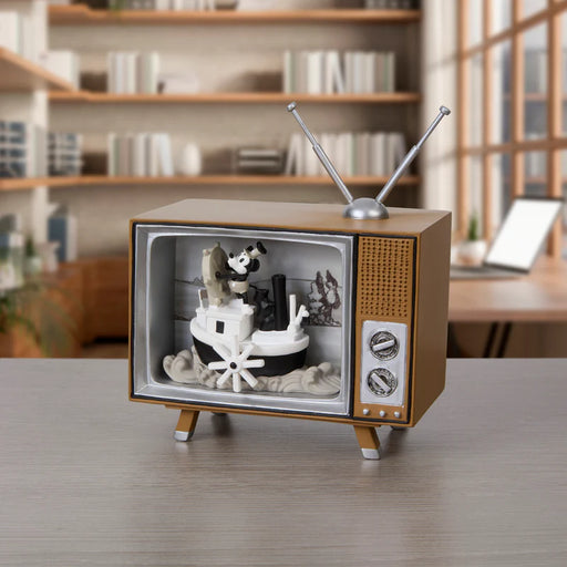 Vintage-style toy television with a panda cake inside on a wooden surface.