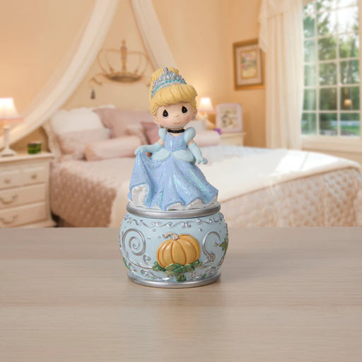 Cinderella figurine in a decorative box on a table with a blurred bedroom background