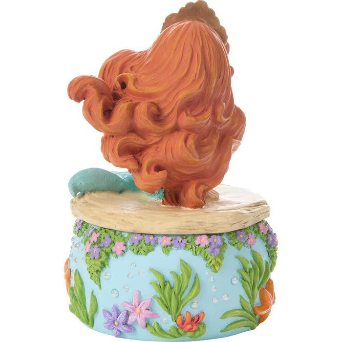 Decorative figurine of a mermaid with flowing hair on a blue base with floral and seaweed design.