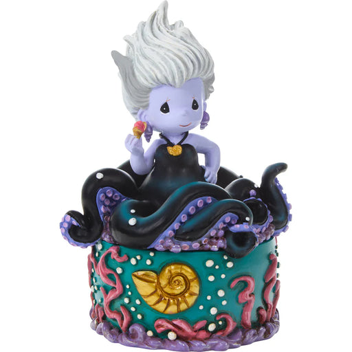 Colorful figurine of a character with white hair and purple outfit on a decorative base.