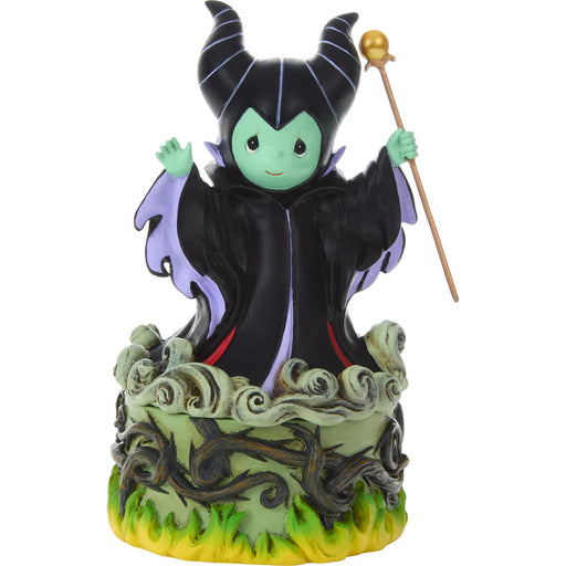 Figurine of a character in a black outfit with green skin, holding a staff on a white background.