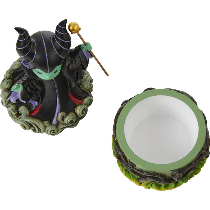 Decorative figurine of a witch with a green base on a white background