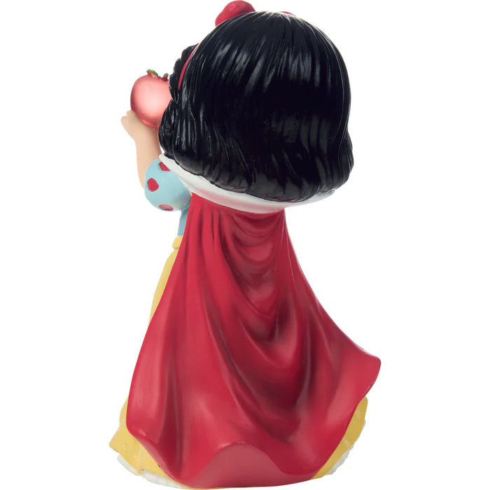 Figurine of a character with a red cape and black hair on a white background