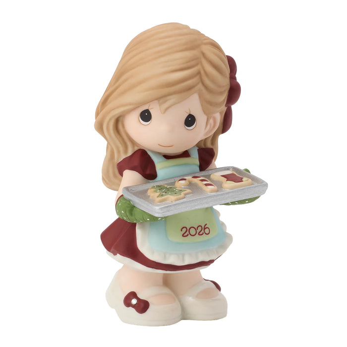 Figurine of a girl holding a tray of cookies with '2026' on an apron, on a white background