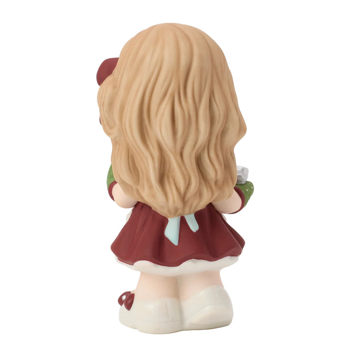 Small figurine of a girl with long blonde hair and a red dress on a white background