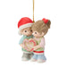A Precious Moments Christmas ornament depicting a young boy in a red Santa hat and a young girl with a red bow holding a heart-shaped candy cane with '2026' written on it, suspended by a gold string against a white background.