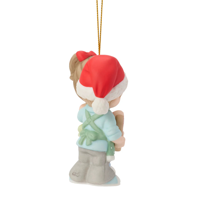 Christmas ornament of a child wearing a red Santa hat on a white background
