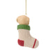 A Christmas ornament shaped like a baby bootie sock, featuring a cream-colored knit texture, a green cuff, a red heel, and a red stripe near the toe, hanging from a gold string on a white background.