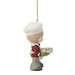 Christmas ornament of a person with a white hat and red coat holding a gift, on a white background.