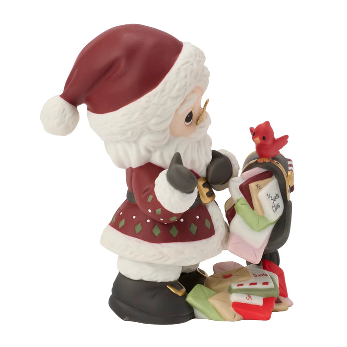 Santa Claus figurine holding a list and a bird on a white background