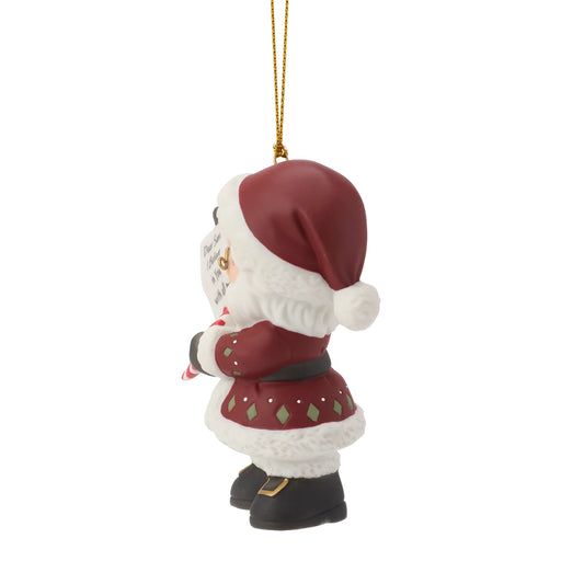 Christmas ornament of a small figure in a Santa hat and coat on a white background