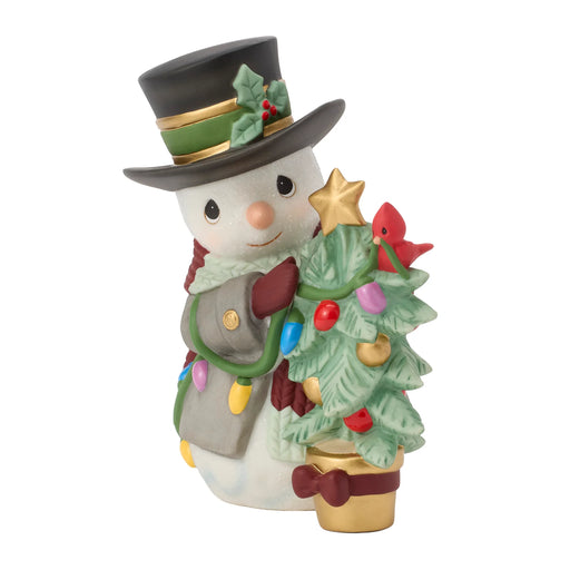 Decorative snowman figurine with a top hat, tree, and Christmas lights on a white background