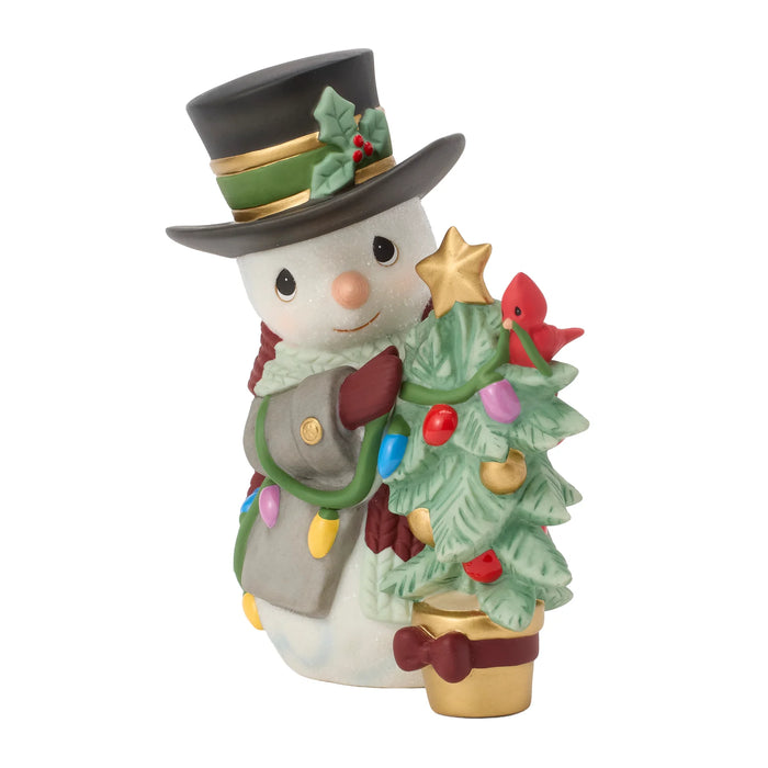 Decorative snowman figurine with a top hat, tree, and Christmas lights on a white background