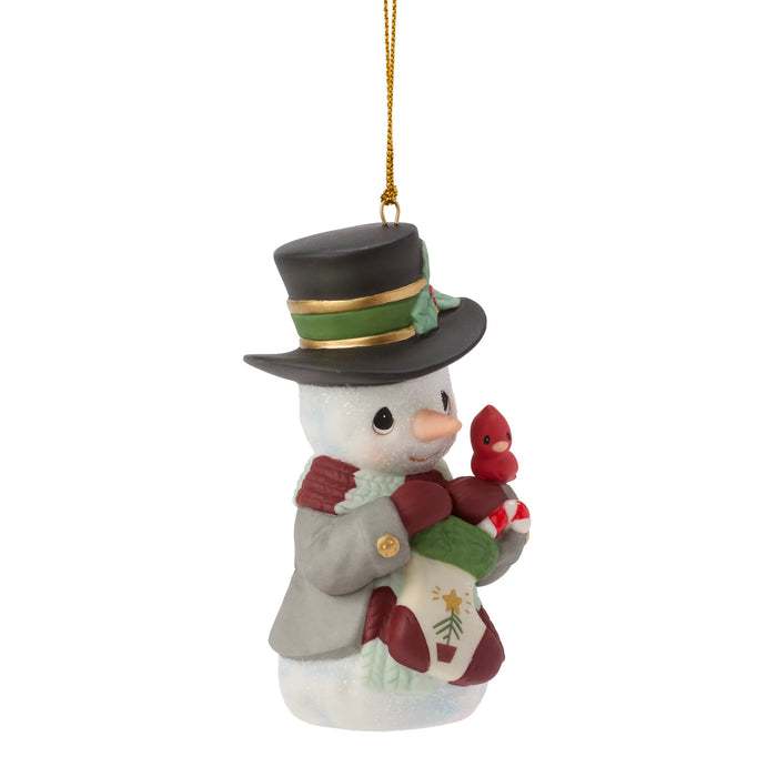 Decorative snowman ornament with a top hat, scarf, and red bird on a white background