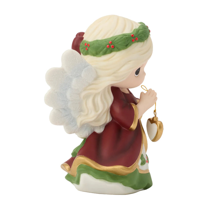 Decorative angel figurine with a wreath and heart-shaped object on a white background