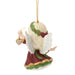 A Christmas angel ornament shown from the back, featuring white wings, a cream-colored wig, a green holly headband with red berries, and a maroon dress with green and gold trim. The ornament is suspended by a gold string against a plain white background.