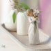 Decorative figurine of a woman holding flowers on a surface with blurred background