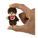 A small brown plush monkey toy with a red-and-white chest emblem, shown being held between a person's fingers against a plain white background.