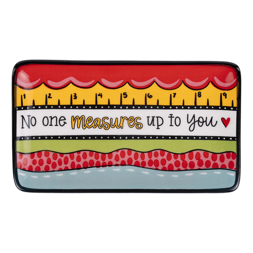 Decorative tray with a ruler design and motivational quote on a white background