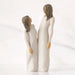 Two ceramic figures of women holding hands on a white background