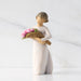 Figurine of a woman holding flowers with '2026' on a white background
