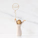Decorative figurine of a person holding a balloon with '2026' on a white background