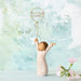 Decorative figurine of a person holding a balloon with '2026