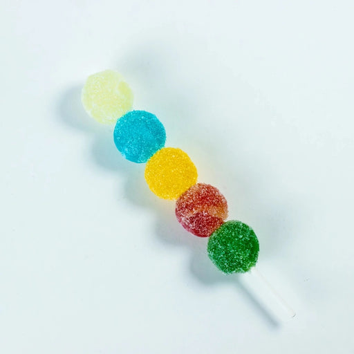Colorful gummy candy on a stick against a white background